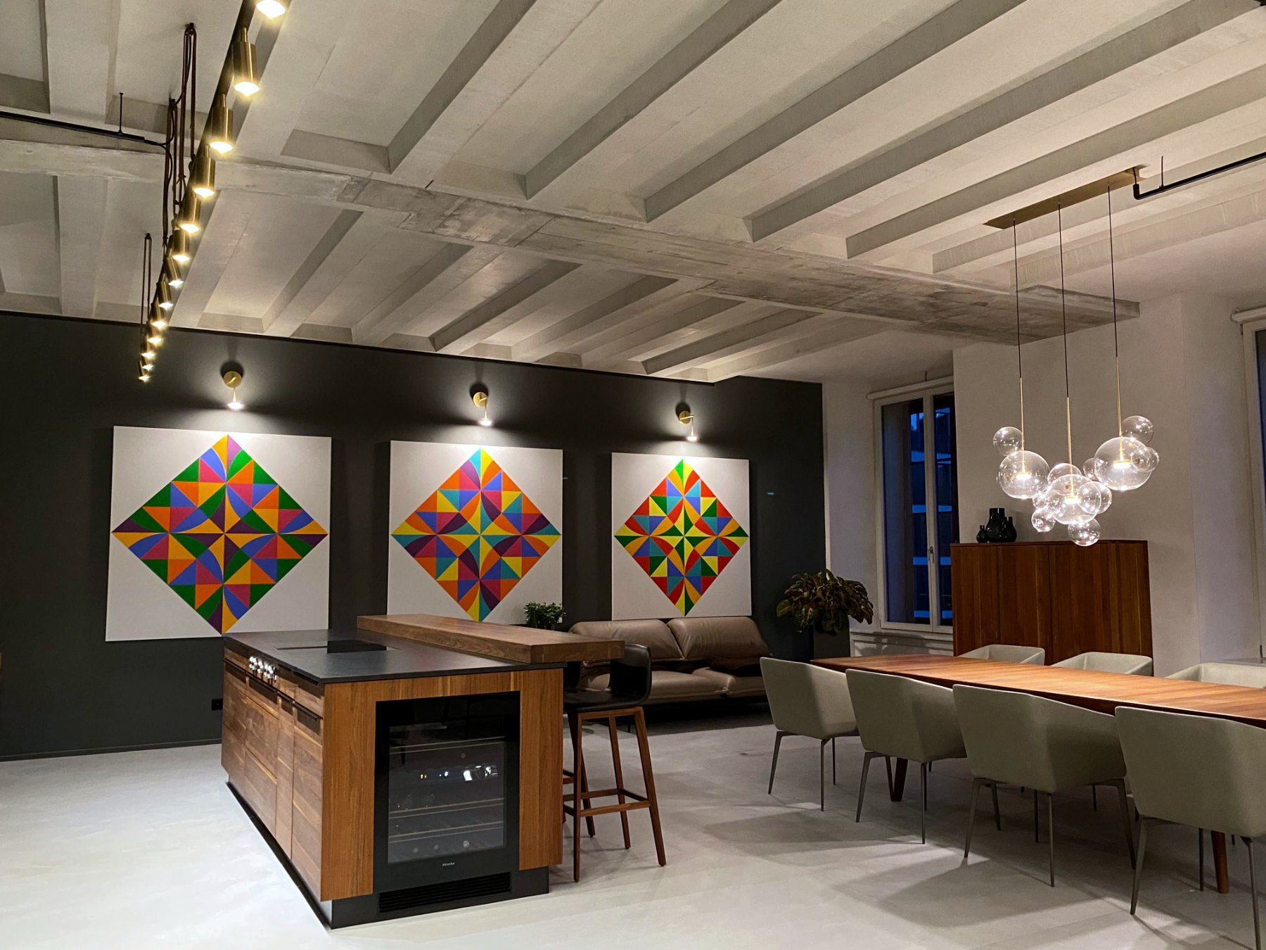 Open-plan kitchen, dining and salon with a triptych of geometric paintings